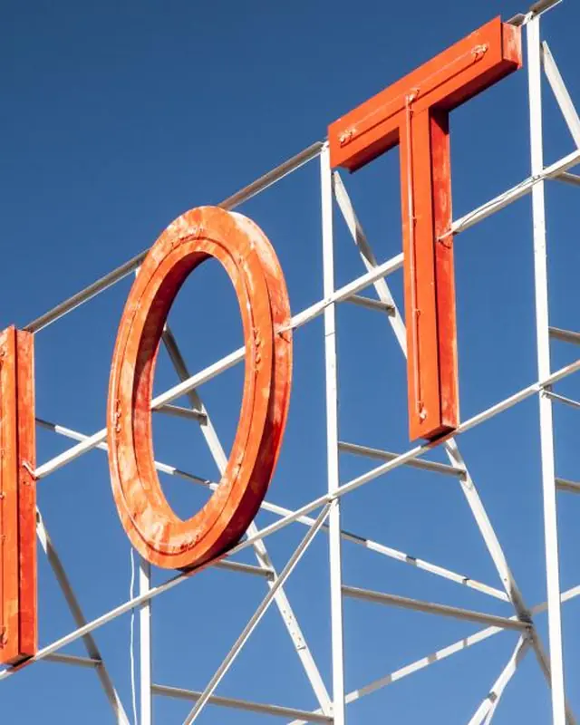 Red rooftop channel letters against a blue sky